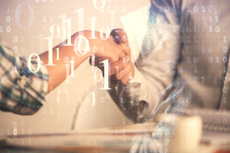 Double exposure of data theme hologram and handshake of two men. Partnership in IT industry concept.