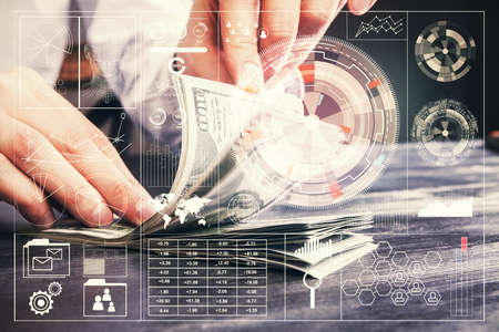 Double exposure of technology drawing hologram and us dollars bills and man hands. Data concept