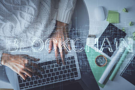 Double exposure of woman hands working on computer and blockchain theme hologram drawing. Top View. bitcoin cryptocurrency concept.の写真素材