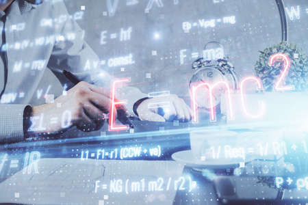 Double exposure of man's hands holding and using a phone and formulas drawing. Education concept.