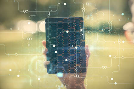 Double exposure of technology sketch hologram and woman holding and using a mobile device. Ai...