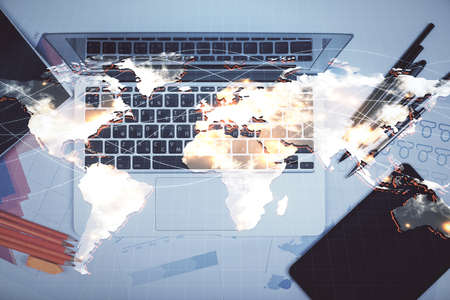 Business theme hologram drawings over computer on the desktop background. Top view. Multi exposure. Concept of international connections.の写真素材