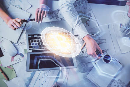 Double exposure of man and woman working together and crypto finance theme hologram. Blockchain...