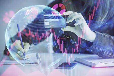 Multi exposure of woman on-line shopping holding a credit card and financial theme drawing. Business...