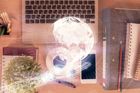 Double exposure of map hologram drawing over desktop. Top view. International connection concept.の写真素材