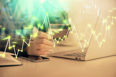 Multi exposure of woman on-line shopping holding a credit card and financial graph drawing. Stock...