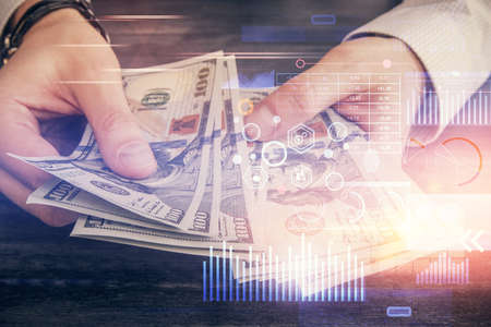Multi exposure of technology drawing hologram and us dollars bills and man hands. Data concept
