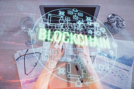 Double exposure of woman hands working on computer and blockchain theme hologram drawing. Top View....