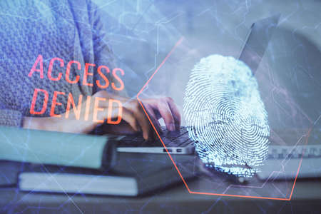 Double exposure of woman hands typing on computer and fingerprint drawing. Security concept.