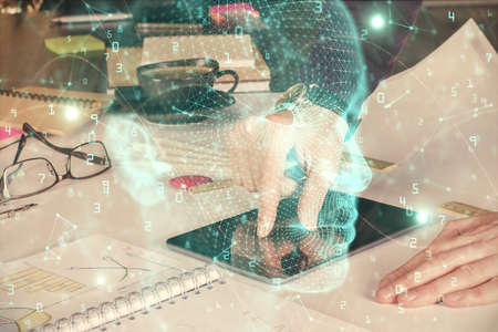 Double exposure of man's hand holding and using a digital device and brain hologram drawing. Data...