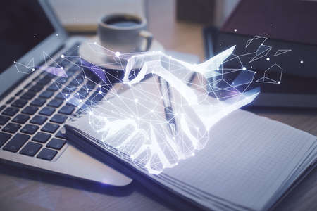 Double exposure of handshake drawing and desktop with coffee and items on table background. Concept of partnershipの写真素材