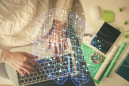 Double exposure of woman working on computer andhuman brain hologram drawing. Top View. Ai concept.