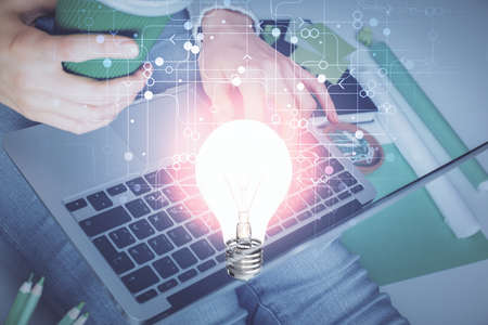 Double exposure of woman hands typing on computer and light bulb drawing. Idea concept.