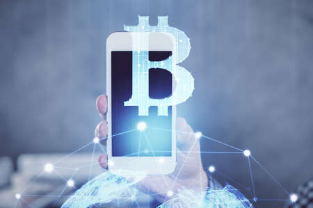 Double exposure of man's hands holding and using a phone and crypto currency blockchain theme drawing.の写真素材