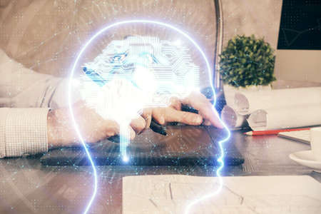 Double exposure of man's hand holding and using a digital device and brain hologram drawing. Data...