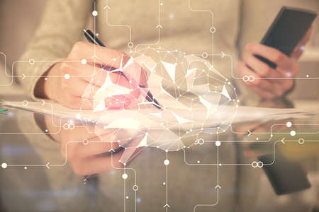 Double exposure of brain sketch hologram and woman holding and using a mobile device.