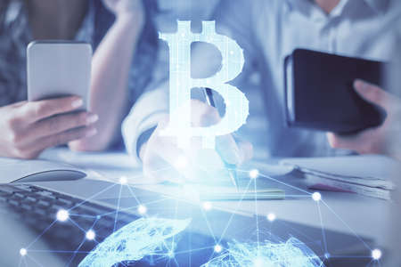 Double exposure of man and woman working together and crypto finance theme hologram. Blockchain...