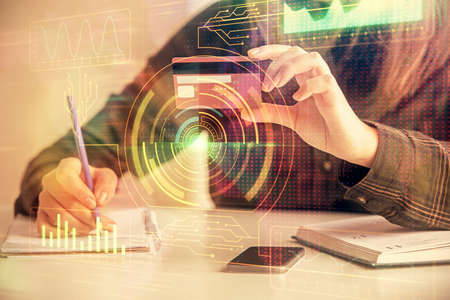 Double exposure of woman on-line shopping holding a credit card and data theme hologram drawing. E-commerce concept.の写真素材