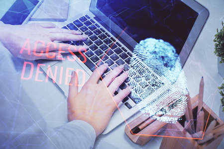 Double exposure of woman hands typing on computer and fingerprint drawing. Security concept.の写真素材