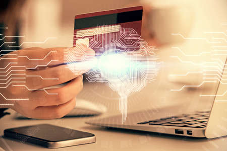 Double exposure of woman on-line shopping holding a credit card and brain hologram drawing. Data...
