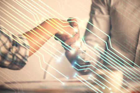 Double exposure of data theme hologram and handshake of two men. Partnership in IT industry concept.