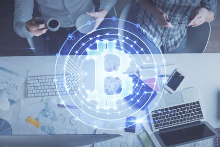 Double exposure of man and woman working together and crypto theme hologram drawing. Computer background. Blockchain concept. Top View.の写真素材