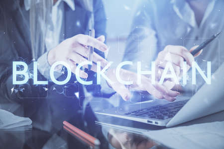 Double exposure of man and woman working together and crypto finance theme hologram. Blockchain business concept. Computer background.の写真素材