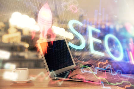 Double exposure of woman hands working on computer and seo hologram drawing. internet search concept.の写真素材
