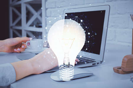 Double exposure of woman hands typing on computer and light bulb drawing. Idea concept.の写真素材