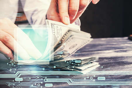 Double exposure of technology drawing hologram and us dollars bills and man hands. Data concept