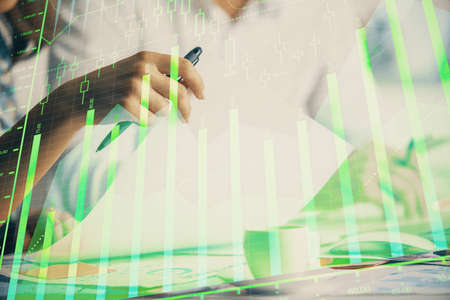 Double exposure of forex graph drawing over people taking notes background. Concept of financial...