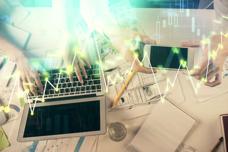 Multi exposure of man and woman working together and forex graph hologram drawing. Financial...