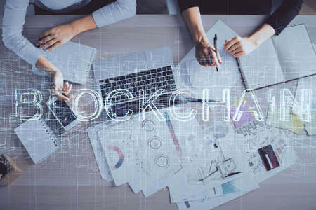 Double exposure of woman hands working on computer and blockchain theme hologram drawing. Top View....