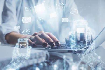 Double exposure of woman hands typing on computer and flying envelop drawing. E-Mail concept.