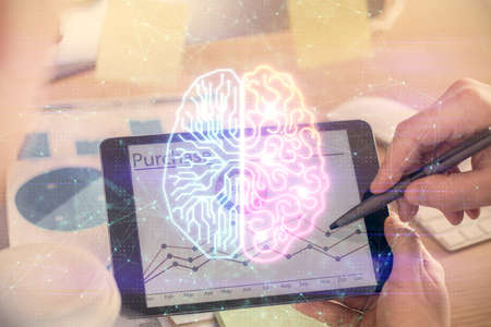 Double exposure of man's hand holding and using a digital device and brain hologram drawing. Data...