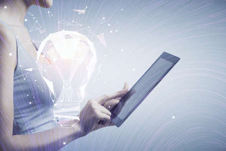 Double exposure of light bulb hologram and woman holding and using a mobile device. Idea concept.