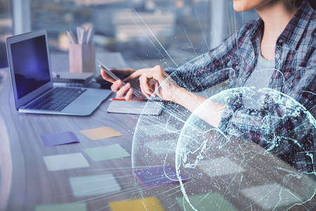 Double exposure of woman hands typing on computer and social network theme hologram drawing. People...