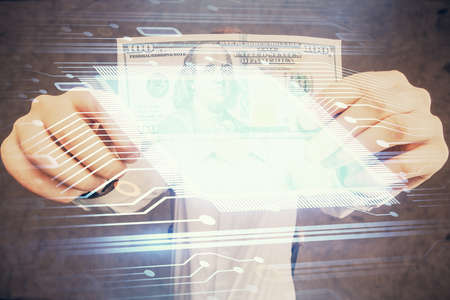 Double exposure of technology drawing hologram and us dollars bills and man hands. Data concept