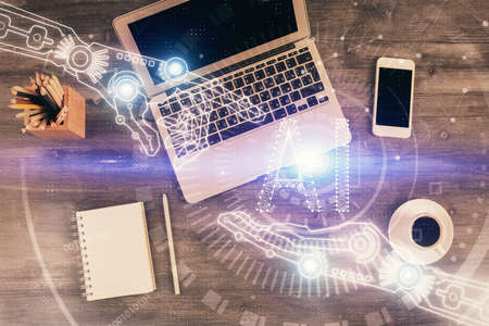 Double exposure of data drawing hologram over topview of study desk background with computer....