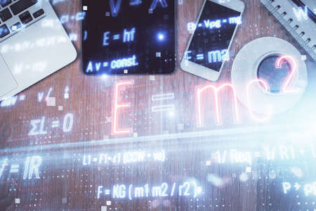 Double exposure of formula drawing over table with phone. Top view. Education concept.の写真素材