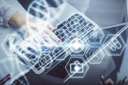 Double exposure of woman hands typing on computer and DNA hologram drawing. Medical education...