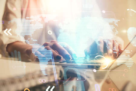 Double exposure of woman hands working on computer and world map hologram drawing. International...
