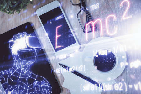 Double exposure of formula drawing over table with phone. Top view. Education concept.の写真素材