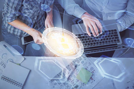 Double exposure of man and woman working together and crypto theme hologram drawing. Computer...