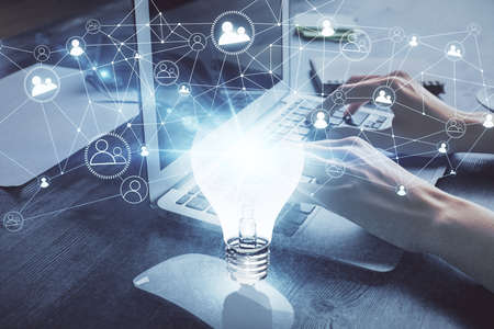 Double exposure of woman hands typing on computer and light bulb drawing. Idea concept.