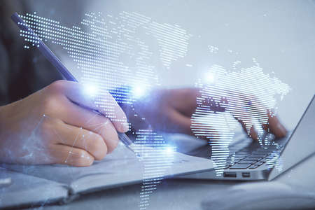 Double exposure of woman hands typing on computer and social network theme hologram drawing. People...