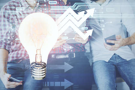 Double exposure of bulb hologram and man and woman working together holding and using a mobile...