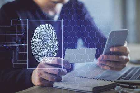 Double exposure of man's hands holding and using a digital device and fingerprint hologram drawing....