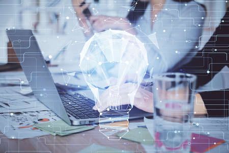 Double exposure of woman hands typing on computer and light bulb drawing. Idea concept.の写真素材