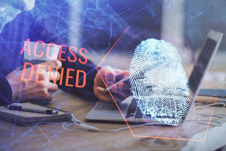 Double exposure of man's hands holding and using a digital device and fingerprint hologram drawing. Security concept.の写真素材